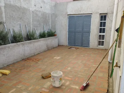 Patio de ladrillos con paredes de hormigón y vegetación — proyecto Comedor, por Deva, en Córdoba