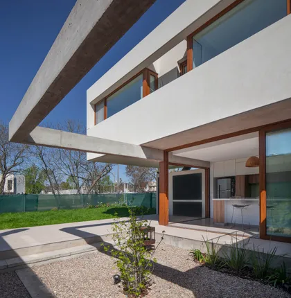 Casa moderna con viga de hormigón en voladizo y patio exterior — proyecto CASA CV, por BUSCETTI & DI BERNARDO arquitectas, en Gonnet