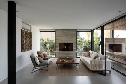 Living moderno con chimenea de hormigón y grandes ventanales — proyecto Lagos del Norte, por Estudio Arq. María Sioli