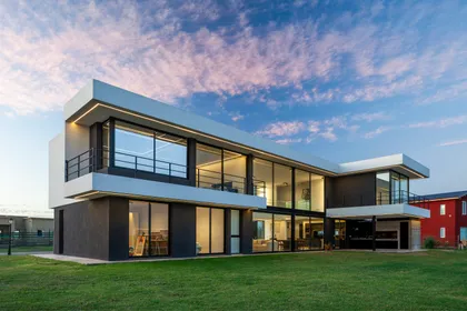 Casa moderna con grandes ventanales y fachada de hormigón y madera — proyecto SS A7, Pilar, por ZUID PORT, en Pilar