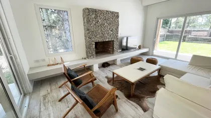 Living moderno con chimenea de piedra y ventanales amplios — proyecto Casa Luvir - Barrio Costa Esmeralda (Partido de la Costa, Buenos Aires) German S, por German Salas arquitectur