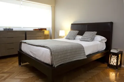 dormitorio moderno con cama baja y detalles en madera — proyecto Departamento en Palermo, por Gutman+Lehrer Arquitectas, en Palermo