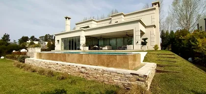 Casa moderna de lujo con piscina infinita y fachada de piedra — proyecto LRCC 249, por LESSI ARQUITECTURA, en Los Cardales