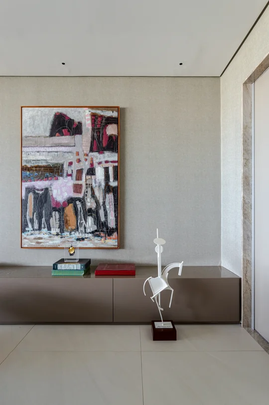 Pasillo minimalista con mueble gris, cuadro abstracto y escultura blanca — proyecto Apto M | E, por Arquitetura Paulo Melo E Paulo