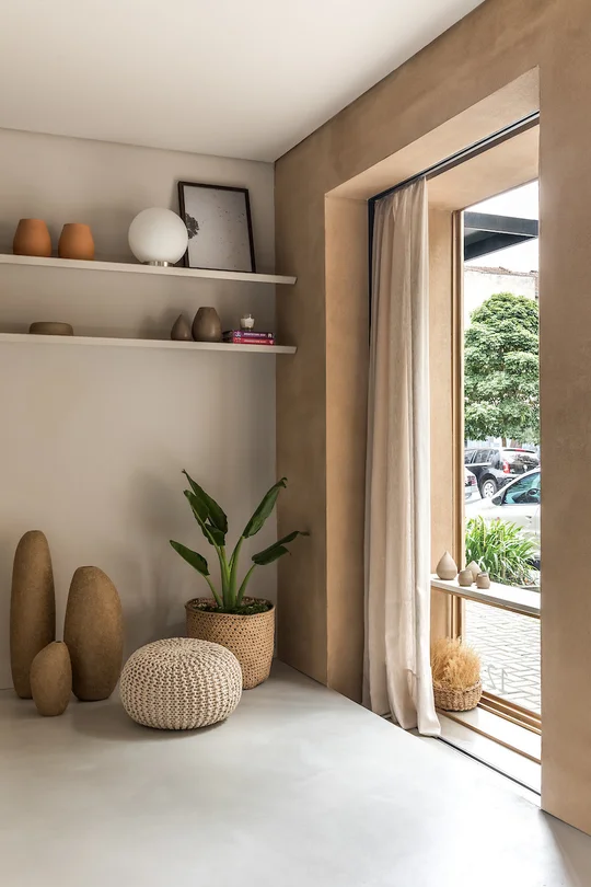 Ambiente de living bohemio con estanterías flotantes y texturas naturales — proyecto Esmo, por Boscardin Corsi Arquitetura