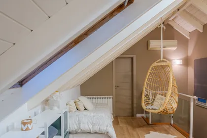 Dormitorio con silla colgante y techo inclinado — proyecto Proyecto Altillo, por efe arquitectura, en Ciudad de Córdoba