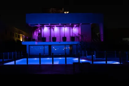 Piscina moderna iluminada con luces azules por la noche — proyecto Casa Pomelo, por FeelX Tecnología SRL, en Canning