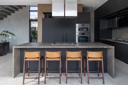 Cocina moderna con isla central, gabinetes oscuros y taburetes industriales — proyecto Casa AL , por ARQUITETARE POR ELAINE ZANON & CLAUDIA MACHADO