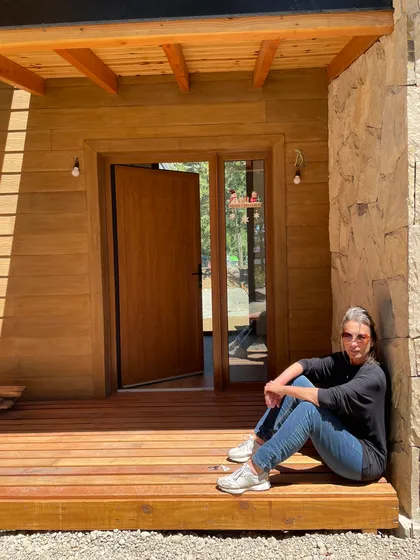 fachada rústica de madera y piedra con deck — proyecto Mountain House, por Arquitecta Grace Overgaard, en San Carlos de Bariloche