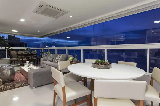 Terraza moderna de noche con vista panorámica y mobiliario contemporáneo — proyecto Varandas, por Xico Diniz