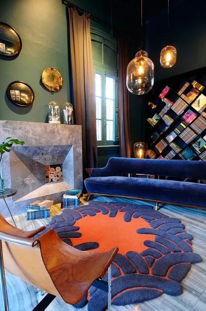Living moderno con sofá azul, sillón cognac y detalles en naranja — proyecto Casa FOA 2019 Espacio 18, por Estudio Diez Muzzio