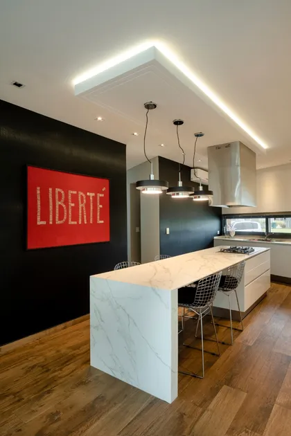 Cocina moderna con isla de mármol y cuadro 'LIBERTE' — proyecto Terravista II, por Yac Interiorismo, en General Rodríguez