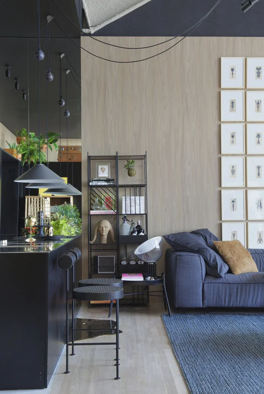 Living moderno con sofa azul, biblioteca negra y pared de madera clara — proyecto Casa COR 2017, por Studio Ro-ca