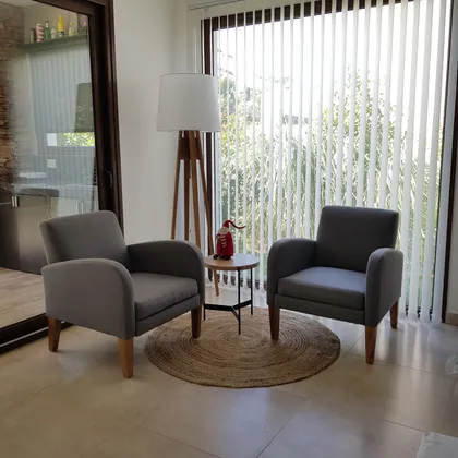 Sala de estar moderna con dos sillones grises y gran ventana — proyecto Casa FA, por Vicky Hurrell, en Mar del Plata