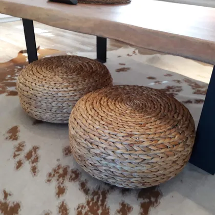 Poufs de rattan sobre alfombra de vaca junto a mesa de madera — proyecto Proyecto VC, por Vicky Hurrell, en Mar del Plata