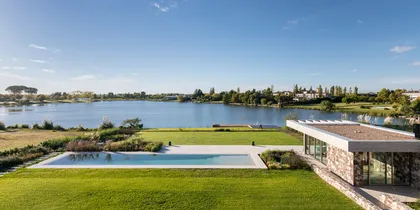 Pileta infinita moderna junto a lago con arquitectura contemporánea — proyecto Propiedad en Nordelta, por MARCO GUOLI PHOTO, en Nordelta