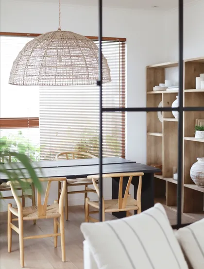 Comedor con lámpara de mimbre, sillas wishbone y estantería abierta — proyecto SPD, por Grupo Pauta Arquitectura