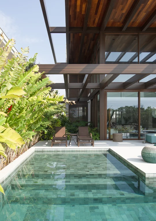 Pileta con azulejos verdes bajo pergola madera y ventanales grandes — proyecto Casa C.A.P., por Ruschel Arquitetura e Urbanism