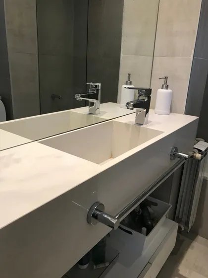Bano minimalista con mesada doble blanca y espejo decorativo — proyecto Casa en Martinez, por Rioja Arquitectura, en Martínez