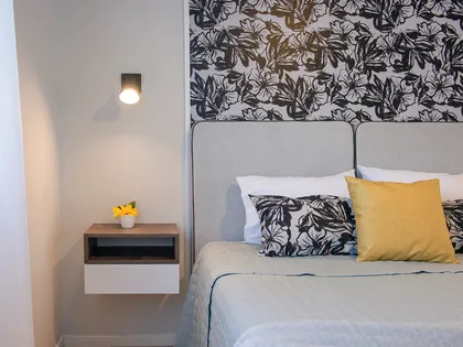 Dormitorio con papel tapiz botánico y cama beige — proyecto Alto Panorama, por Interiores a la carta, en Córdoba