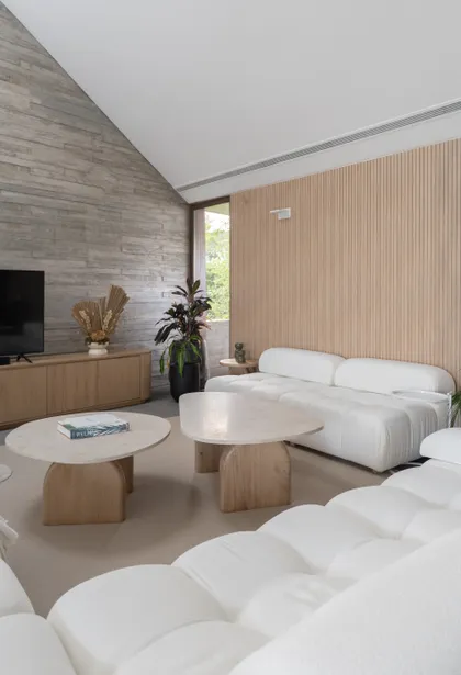 Sala de estar moderna con techo inclinado y pared de listones de madera — proyecto PROYECTO NAUDIR, por July Acosta Home, en Belén de Escobar