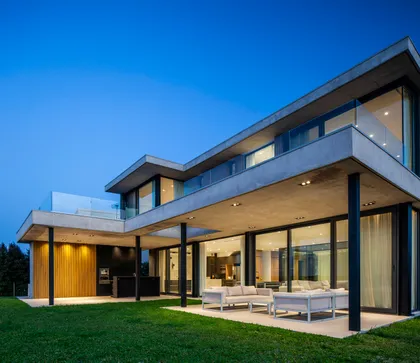Fachada de casa moderna con hormigón visto y ventanales — proyecto CASA MUELLES 239, por ABAD GADANO, en Belén de Escobar