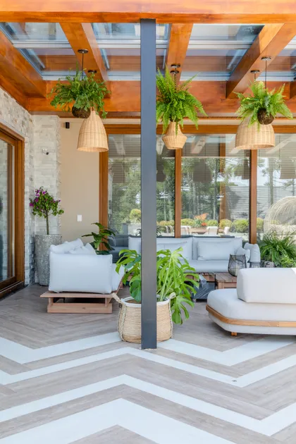 Terraza moderna con piso de madera, pérgola y plantas colgantes — proyecto Projeto Destaque Club&Casa, por OKA ARQUITETURA