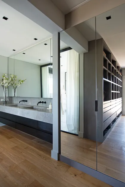 Baño moderno con vanitory de piedra, closet abierto y pisos de madera — proyecto Santa Maria De Tigre, por Parq Estudio, en Tigre