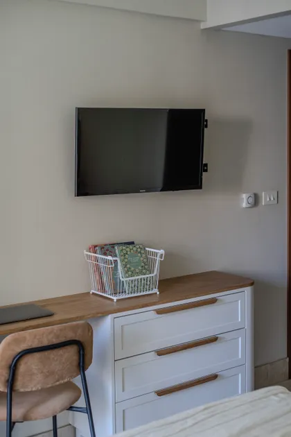 Dormitorio moderno con TV de pared y mueble de cajones blanco — proyecto Bustamante, por Blue Rabbit Design, en Palermo