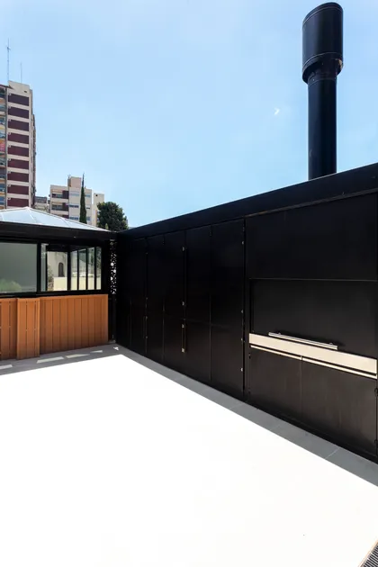 Terraza moderna con parrilla y fachada negra — proyecto JURAMENTO, por Nima Estudio, en Buenos Aires
