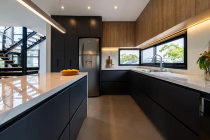 Cocina moderna con isla grande y revestimiento de madera — proyecto Santa Isabel - Andrea Gonzalez, por ABEJA CONCEPT, en Nordelta