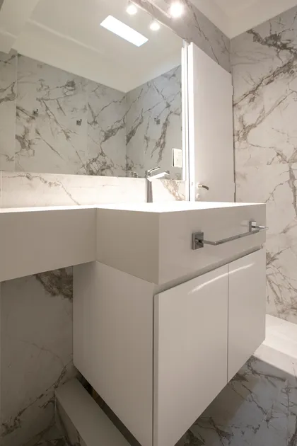 Baño moderno con mármol y vanitory blanco flotante — proyecto Obra Martinez A, por Arq. Lourdes Yarade Saravia, en Martínez