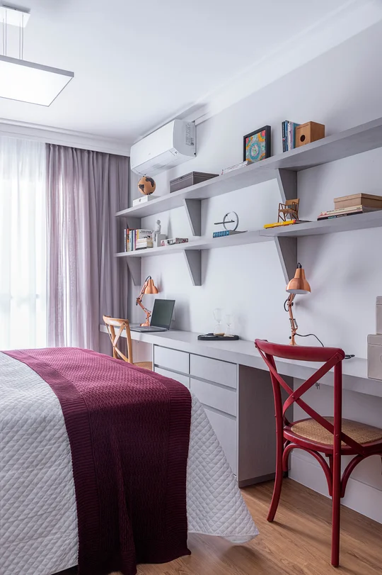 Dormitorio con escritorio, estanterías grises y silla roja junto ventanal — proyecto Min. Rocha Azevedo, por Carina Dal Fabbro Arquitetura