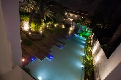 Piscina moderna con iluminación LED azul y deck de madera — proyecto Detalles, por Geo Estudio, en Buenos Aires