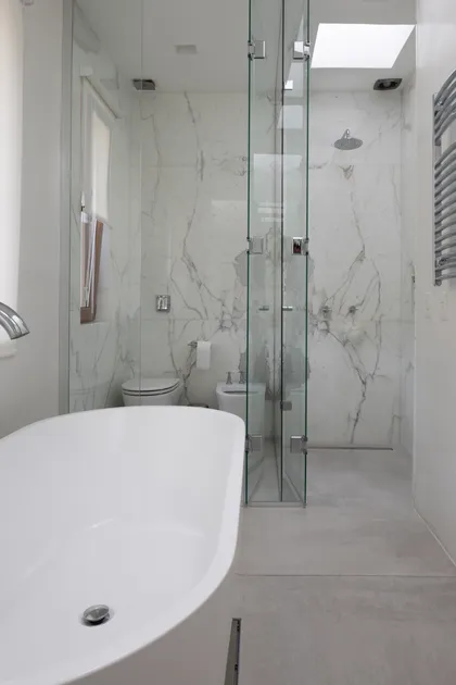 Baño moderno con bañera exenta y ducha de cristal — proyecto CASA OrAz, por Alfredo Orfila arquitectura, en San Isidro