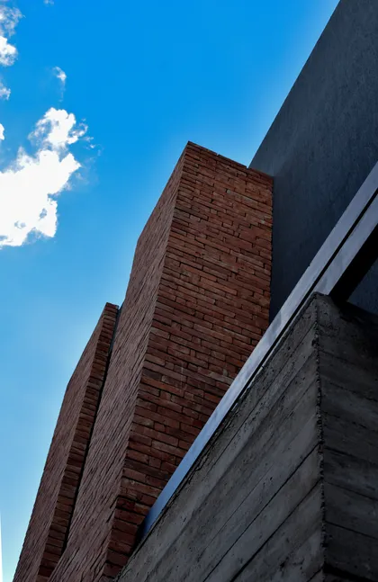 Fachada moderna de ladrillo y hormigón visto contra el cielo azul — proyecto CASA HC, por Daniel Daniele - Oficina de Arquitectura, en Canning
