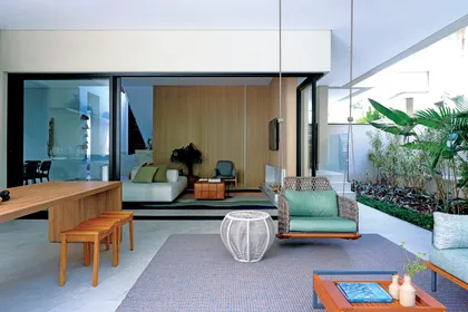 Amplio living moderno con paredes de madera y grandes ventanales al jardín — proyecto Projeto Destaque Club&Casa, por Barbara Dundes – Arquitetura + Design