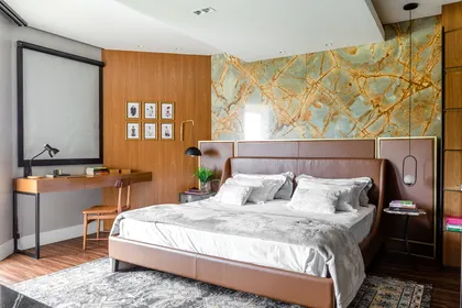 Dormitorio lujoso con pared de piedra y madera, cama de cuero — proyecto Apê Através da Arte, por M.Hausen Arquitetura