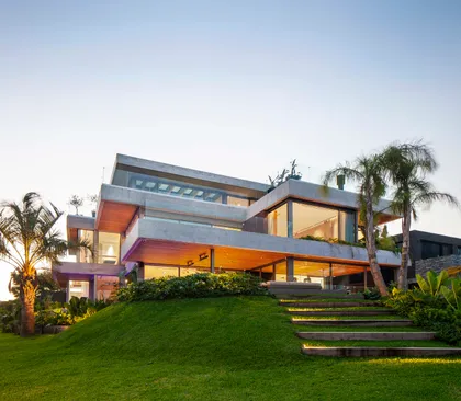 Fachada moderna de casa con niveles escalonados y amplios ventanales — proyecto Water House, por Remy Arquitectos, en Rincón de Milberg