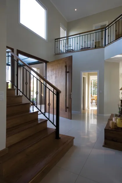 Escalera de madera con barandal hierro negro en hall doble altura — proyecto Racionalismo Moderno, por Ciba Arquitectura