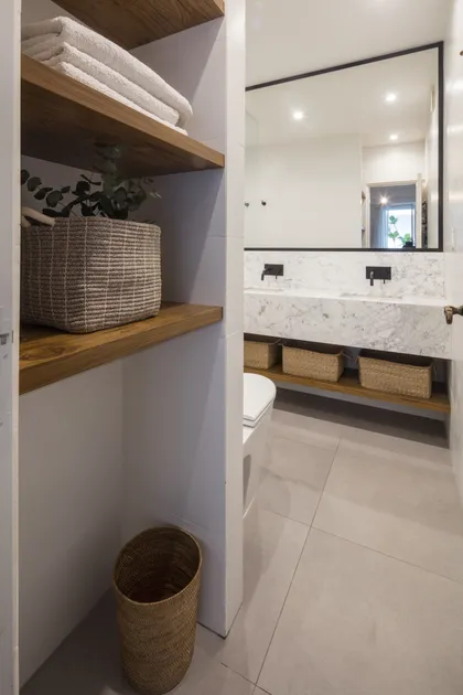 Baño moderno con estanterías de madera y doble vanitory — proyecto Juncal, por Parq Estudio, en CABA