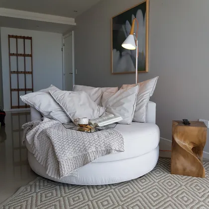 Living moderno con sillón circular blanco y lámpara de pie arqueada — proyecto Departamento MH, por Vicky Hurrell, en Mar del Plata