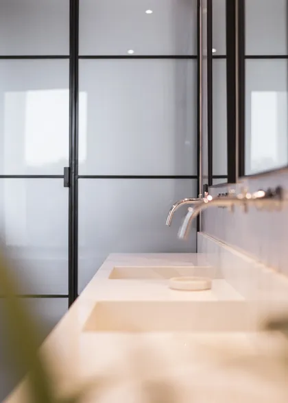 baño moderno con doble bacha de piedra y grifería empotrada — proyecto CASA PILARÁ, por CRUZ, en Pilará