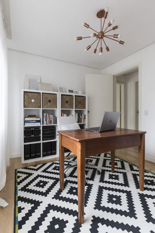 Oficina moderna con escritorio madera, estantería blanca y piso geométrico — proyecto Apartamento 201, por Camila Cavalheiro Arquiteta