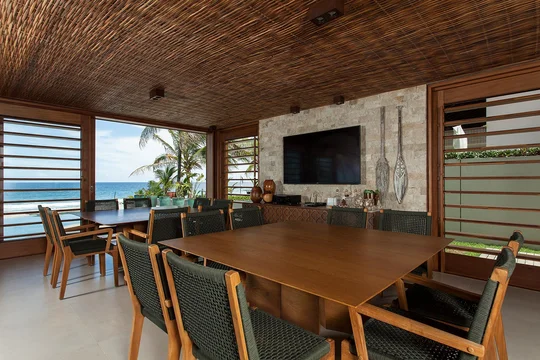 Comedor con vista al mar, mesa madera, techo revestido, ventanal — proyecto Residência CM, por Milcent Arquitetura