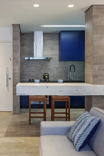Cocina moderna abierta con mesada de mármol y acabados en hormigón — proyecto APARTAMENTO VJ, por Frederico Bicalho Arquitetura