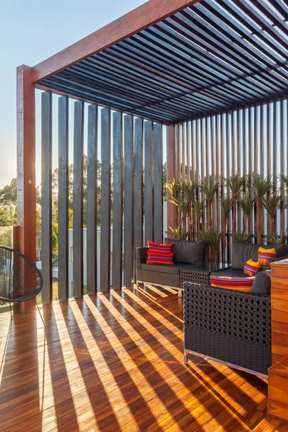 Terraza moderna con pergola, deck de madera y muebles negros — proyecto CASA RR, por Frederico Bicalho Arquitetura