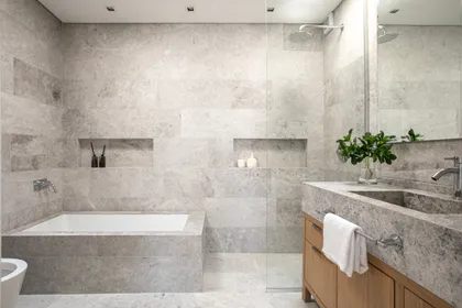 Baño moderno con mármol gris, bañera exenta y grifería empotrada — proyecto Larrea, por Parq Estudio