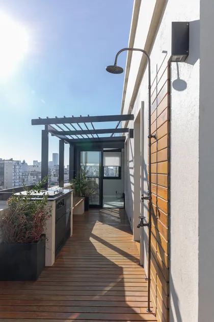 Terraza de balcón moderna con ducha exterior y parrilla exterior — proyecto Viamonte II, por WA arquitectura, en CABA
