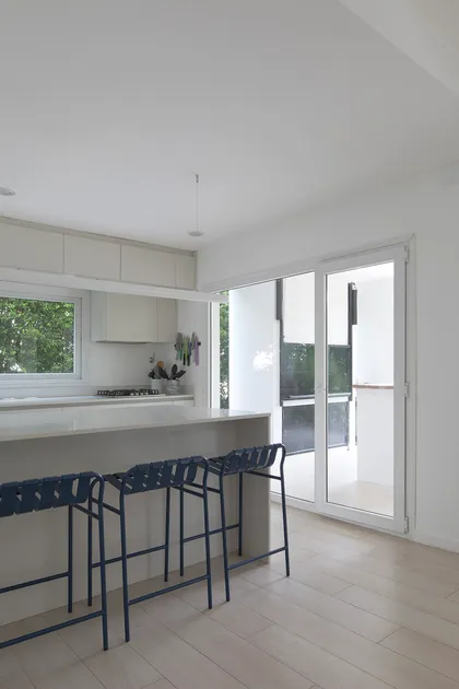 Cocina moderna con isla, barra y ventanales amplios — proyecto Reforma Isla del Sol, por Estudio YME, en Rincón de Milberg